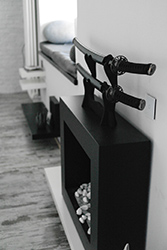 Closer look of the fireplace, sitting area on the windowsill and decorative shelves.