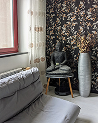 Japanese futon as a guest bed, curtain with traditional Chinese prosperity symbol and Buddha statue.
